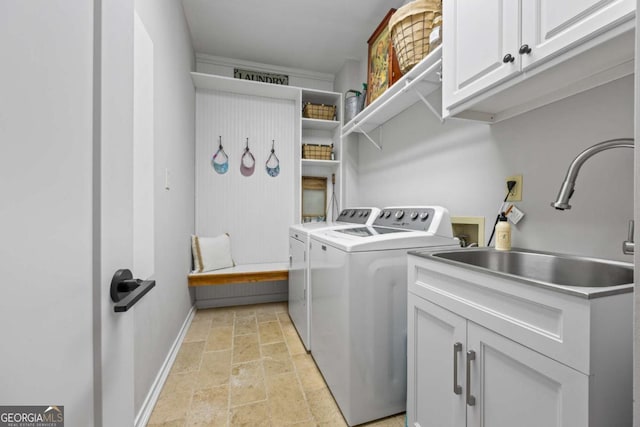 laundry area featuring cabinet space, washer and dryer, stone tile flooring, and baseboards
