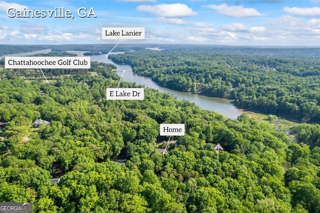 drone / aerial view of a heavily wooded area and a large body of water