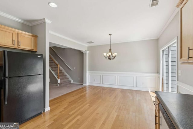 kitchen with freestanding refrigerator, a chandelier, light wood-style flooring, crown molding, and dark countertops