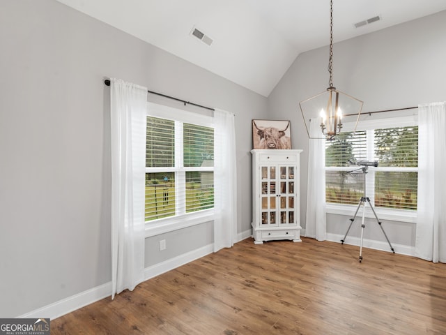 111 Walnut Ln, Williamson, GA 30292 - unfurnished dining area with a chandelier, baseboards, wood finished floors, and lofted ceiling