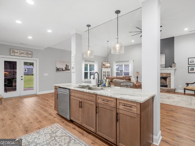111 Walnut Ln, Williamson, GA 30292 - kitchen with stainless steel dishwasher, a sink, open floor plan, a fireplace with raised hearth, and light wood finished floors