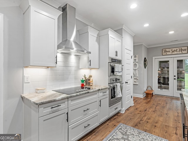 111 Walnut Ln, Williamson, GA 30292 - kitchen with black electric cooktop, wall chimney range hood, ornamental molding, double oven, and decorative backsplash