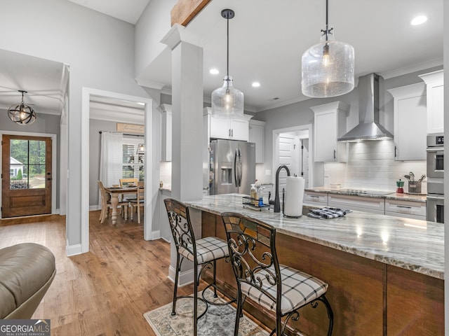 111 Walnut Ln, Williamson, GA 30292 - kitchen with appliances with stainless steel finishes, wall chimney exhaust hood, crown molding, decorative backsplash, and a breakfast bar area
