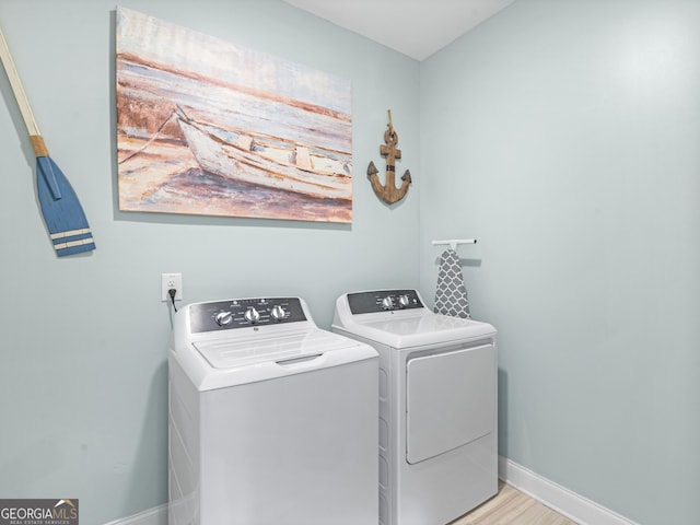 111 Walnut Ln, Williamson, GA 30292 - clothes washing area featuring washer and dryer, baseboards, and light wood-style flooring