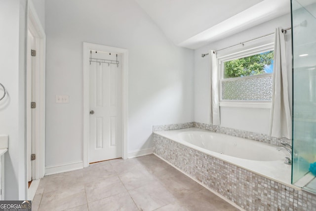 771 James Cir, Lawrenceville, GA 30046 - bathroom featuring lofted ceiling, a relaxing tiled tub, a shower, and tile patterned floors