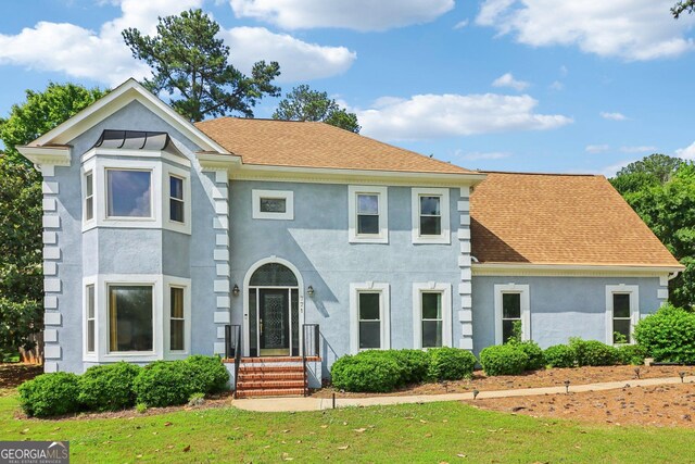 771 James Cir, Lawrenceville, GA 30046 - victorian house featuring stucco siding, a front yard, and a shingled roof