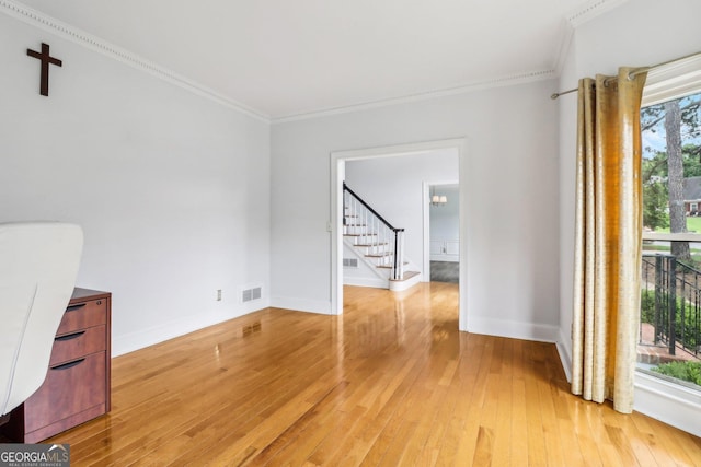 771 James Cir, Lawrenceville, GA 30046 - empty room featuring crown molding, stairs, light wood-style floors, and baseboards