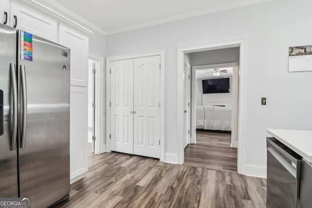 771 James Cir, Lawrenceville, GA 30046 - kitchen with appliances with stainless steel finishes, ornamental molding, wood finished floors, white cabinetry, and a ceiling fan