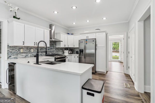 771 James Cir, Lawrenceville, GA 30046 - kitchen featuring appliances with stainless steel finishes, wall chimney range hood, wine cooler, a sink, and backsplash