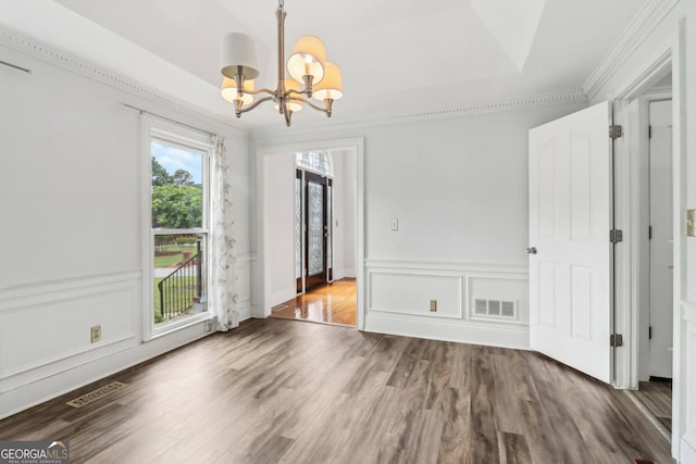 771 James Cir, Lawrenceville, GA 30046 - unfurnished dining area with a chandelier, wood finished floors, ornamental molding, and a decorative wall