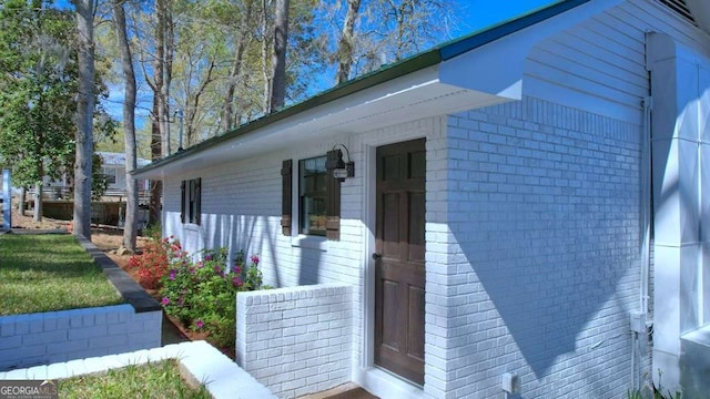 view of side of property featuring brick siding