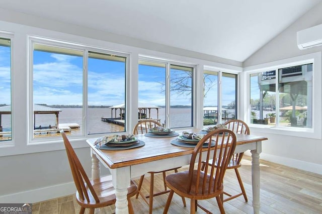 sunroom / solarium with a wall unit AC, vaulted ceiling, and a water view