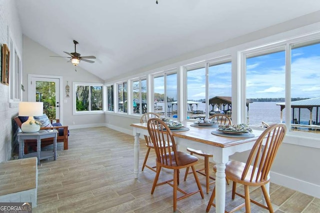 sunroom with vaulted ceiling and a water view