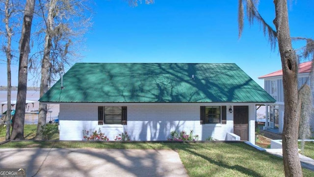 view of front of property with a front yard and metal roof