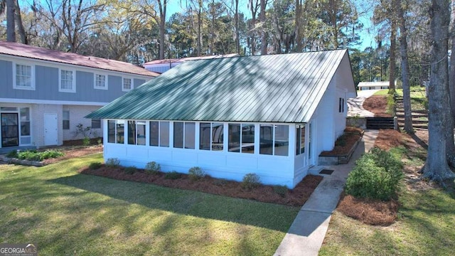 view of home's exterior featuring a sunroom and metal roof