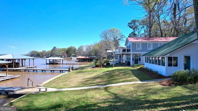 dock area featuring a yard, a water view, and boat lift