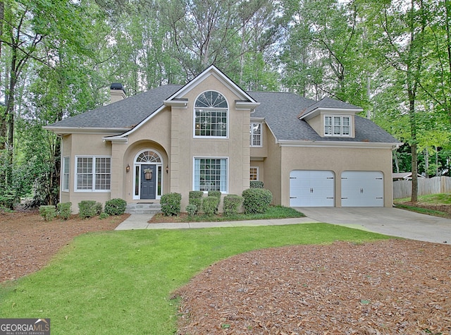 view of front facade with stucco siding, roof with shingles, concrete driveway, and a chimney