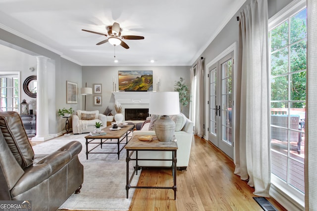 living area with plenty of natural light, ceiling fan, light wood-style flooring, crown molding, and recessed lighting