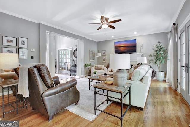 living area featuring a ceiling fan, light wood finished floors, ornamental molding, recessed lighting, and ornate columns