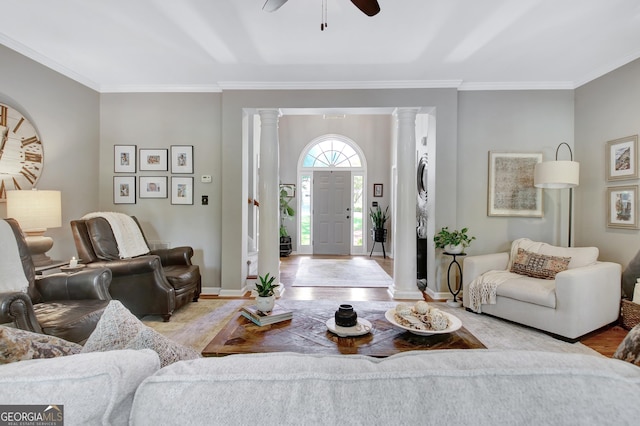 living room with ornate columns, wood finished floors, crown molding, and a ceiling fan