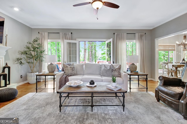 living room featuring healthy amount of natural light, ceiling fan, wood finished floors, and crown molding
