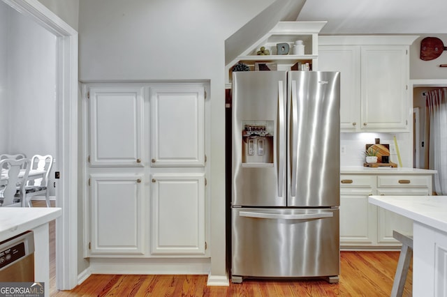 kitchen with stainless steel appliances, white cabinets, and light wood-style flooring