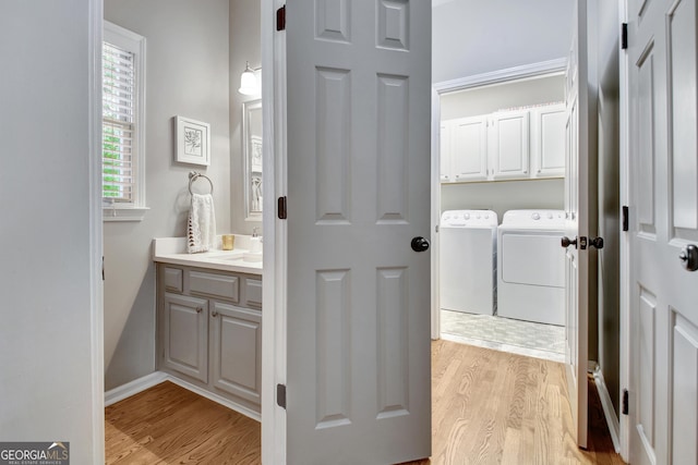 bathroom with washer and clothes dryer, wood finished floors, and vanity