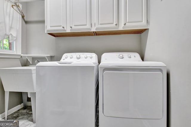 laundry room with washing machine and clothes dryer, marble look tile flooring, cabinet space, and baseboards