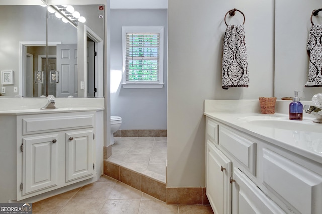 full bath featuring two vanities, tile patterned floors, and toilet