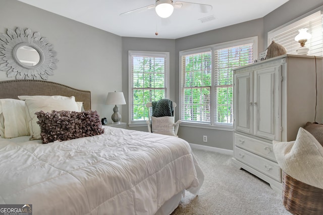 carpeted bedroom featuring multiple windows, baseboards, and a ceiling fan
