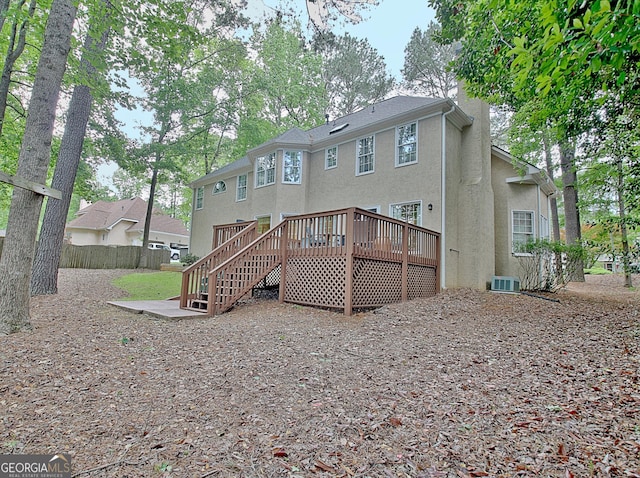 rear view of property featuring stucco siding, fence, a wooden deck, stairway, and cooling unit