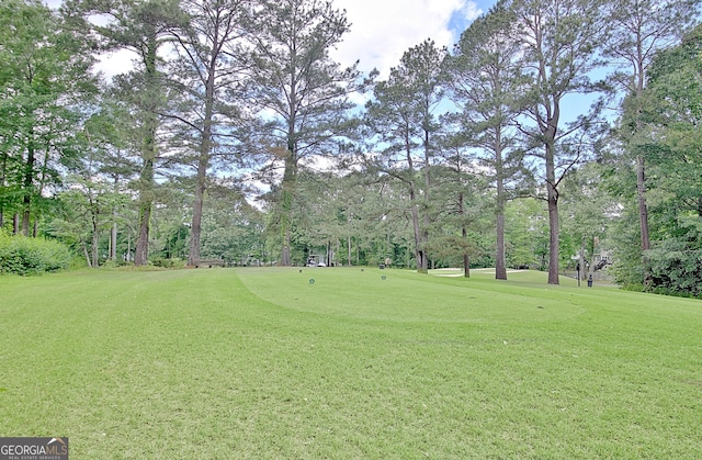 view of home's community featuring view of wooded area and a lawn