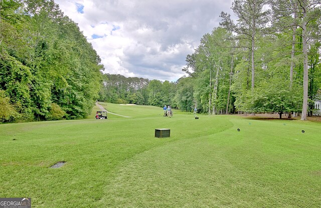 view of property's community featuring a yard, view of golf course, and view of scattered trees