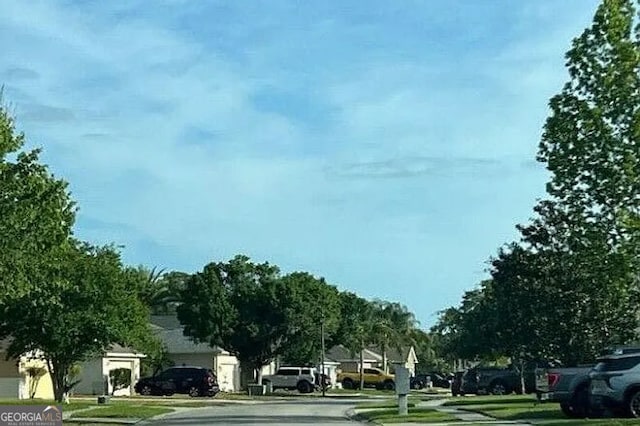 view of asphalt road with curbs and sidewalks
