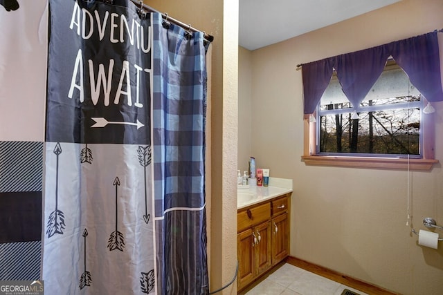bathroom featuring curtained shower, tile patterned floors, vanity, and baseboards