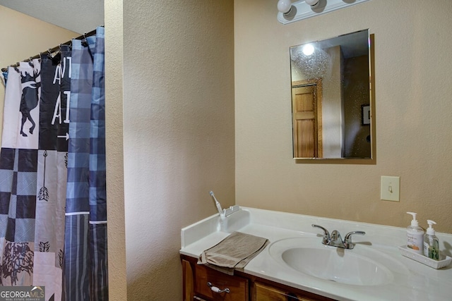 full bathroom featuring vanity, a shower with shower curtain, and a textured wall