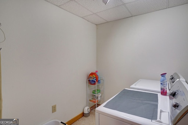 washroom with washing machine and dryer and baseboards