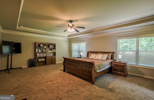 carpeted bedroom featuring a raised ceiling, ornamental molding, baseboards, and ceiling fan