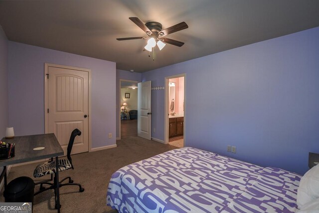 carpeted bedroom with baseboards, ensuite bath, a desk, and ceiling fan