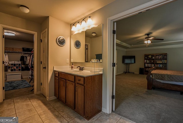 bathroom with a ceiling fan, tile patterned floors, vanity, baseboards, and crown molding