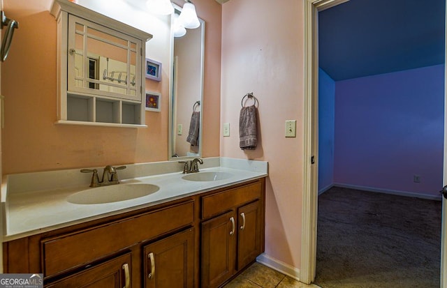 bathroom with double vanity and baseboards