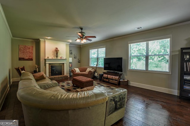 living room featuring crown molding, baseboards, a fireplace, dark wood-style flooring, and ceiling fan