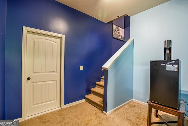 stairway featuring carpet and baseboards
