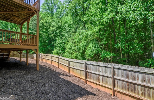 fenced backyard featuring a deck and stairs
