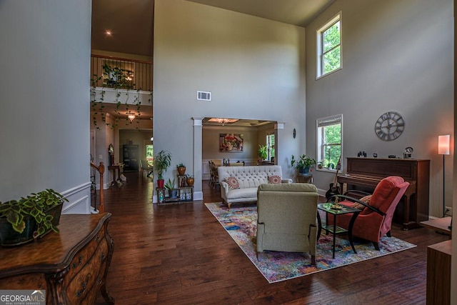 living area featuring a towering ceiling and wood finished floors