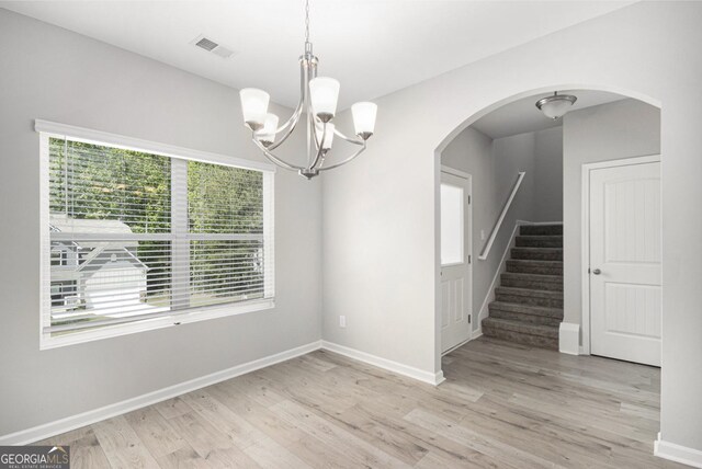 458 Ajo Way, Dallas, GA 30157 - unfurnished dining area featuring light wood-style floors, a chandelier, stairs, and arched walkways