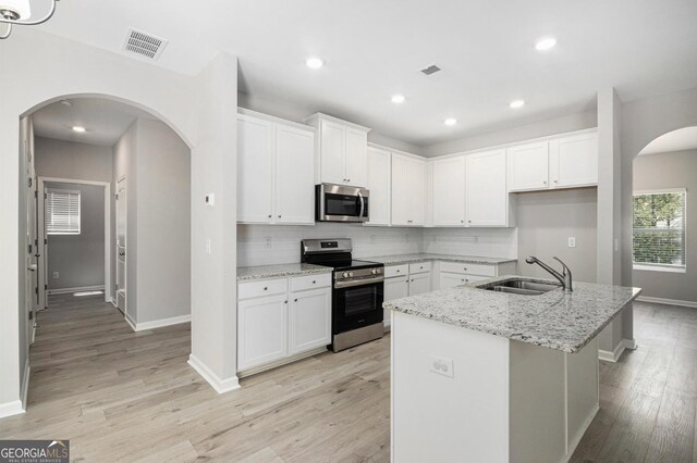 458 Ajo Way, Dallas, GA 30157 - kitchen with stainless steel appliances, light wood finished floors, tasteful backsplash, white cabinets, and recessed lighting