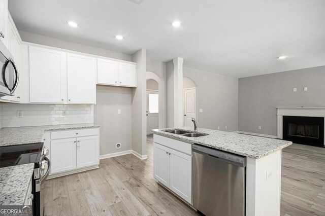 458 Ajo Way, Dallas, GA 30157 - kitchen with stainless steel appliances, arched walkways, light wood finished floors, white cabinetry, and recessed lighting