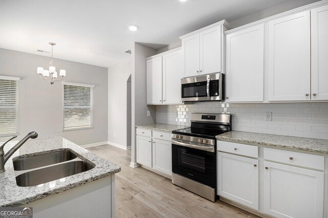 458 Ajo Way, Dallas, GA 30157 - kitchen featuring stainless steel appliances, tasteful backsplash, light wood finished floors, white cabinetry, and a chandelier