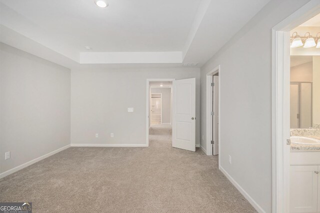 458 Ajo Way, Dallas, GA 30157 - unfurnished bedroom featuring light colored carpet, a tray ceiling, ensuite bath, and recessed lighting